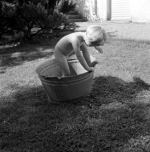 Meisje spelend met een teil water in de tuin van de woning van Bachmann, Bestanddeelnr 254-4612