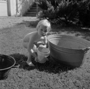 Meisje spelend met een teil water in de tuin van de woning van Bachmann, Bestanddeelnr 254-4610