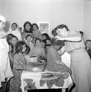 Mejuffrouw Cl Welcker onderzoekt de gezondheid van kinderen in een schooltje in, Bestanddeelnr 255-6557