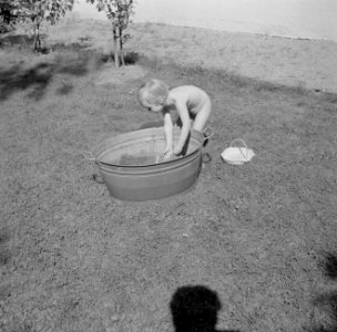 Meisje spelend met een teil water in de tuin van de woning van Bachmann, Bestanddeelnr 254-4611