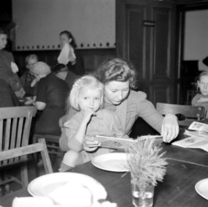 Meisje op schoot bij een vrouw die een boekje leest, Bestanddeelnr 255-9474