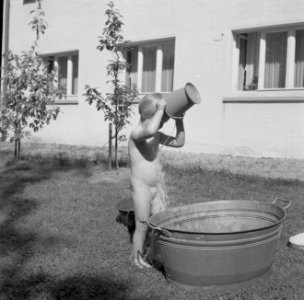 Meisje spelend met een teil water in de tuin van de woning van Bachmann, Bestanddeelnr 254-4625