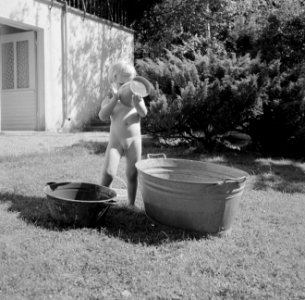 Meisje spelend met een teil water in de tuin van de woning van Bachmann, Bestanddeelnr 254-4624