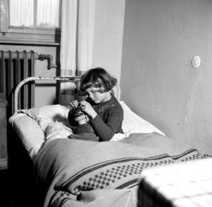 Meisje speelt in bed met een pop, Bestanddeelnr 254-1732