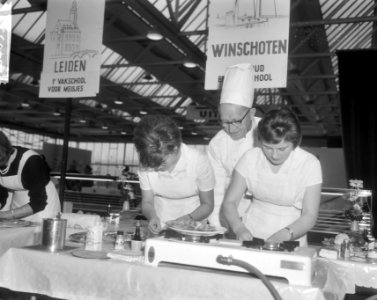 Meisjes bezig met het bereiden van schotels onder toeziend oog van chef-kok H. …, Bestanddeelnr 918-4639