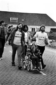 Meelopende demonstranten met T-shirts met tekst Is het hier oorlog, Bestanddeelnr 930-9302