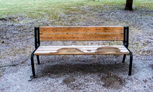 Melted spots on frosty park bench