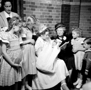 Meisje houdt baby op de arm temidden van vrouwen en kinderen, Bestanddeelnr 255-8597
