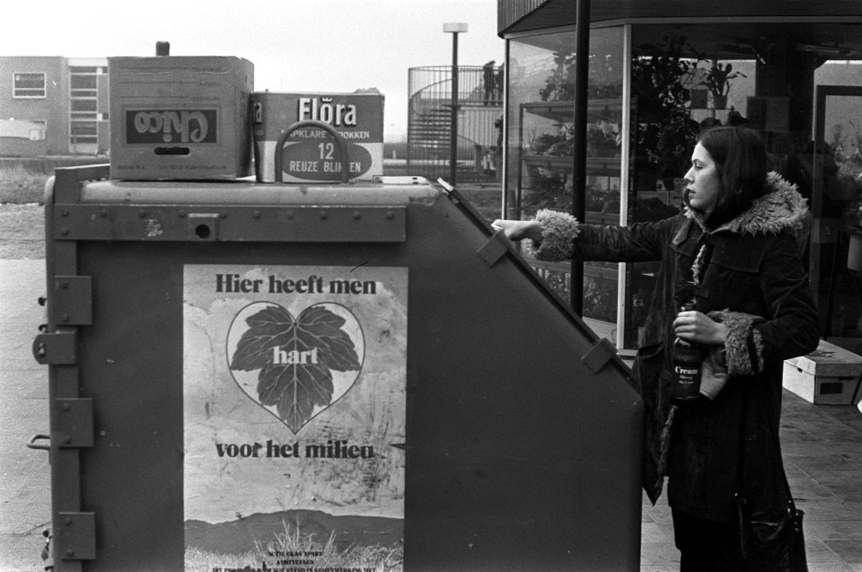 Meisje gooit fles in container ivm milieu-aktie te Amstelveen (glasinzamel-ak, Bestanddeelnr 926-1820