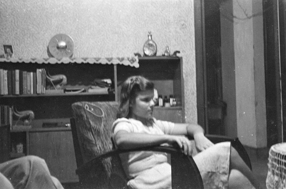 Meisje in stoel in een huiskamer, Bestanddeelnr 41-4-2