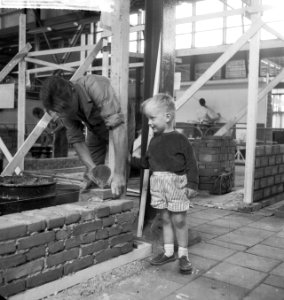 Metselwedstrijd in de Ahoy Hall . Klein jongetje kijkt belangstellend toe, Bestanddeelnr 912-6987