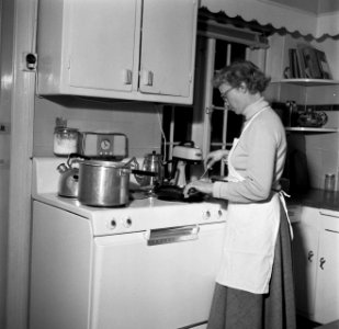 Mevrouw Svendsen in de keuken achter het fornuis met pannen, Bestanddeelnr 252-8763
