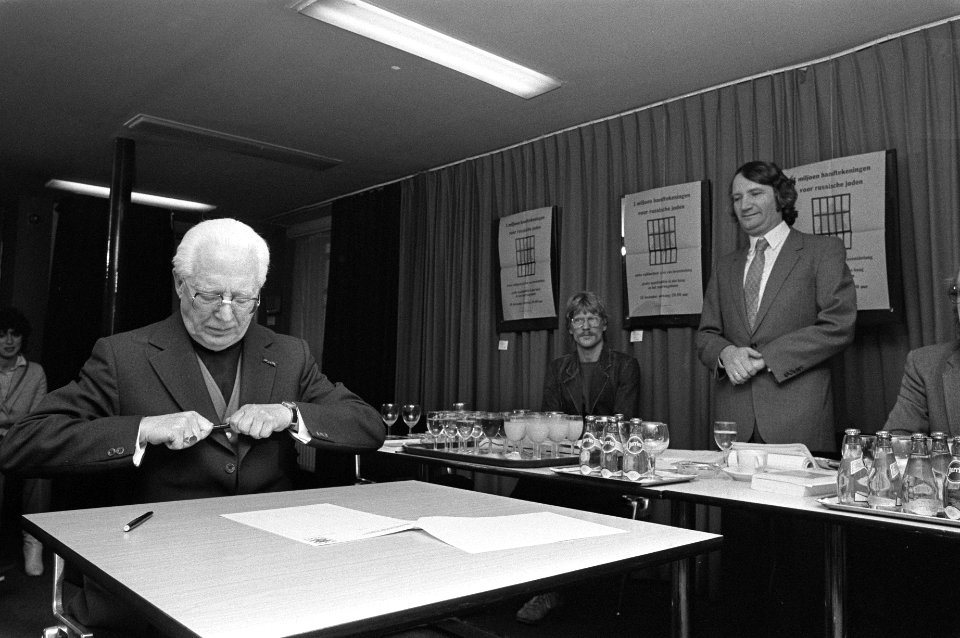 Mgr. Zwartkruis zet handtekening, rechts Rabbijn Soetendorp, Bestanddeelnr 931-8389