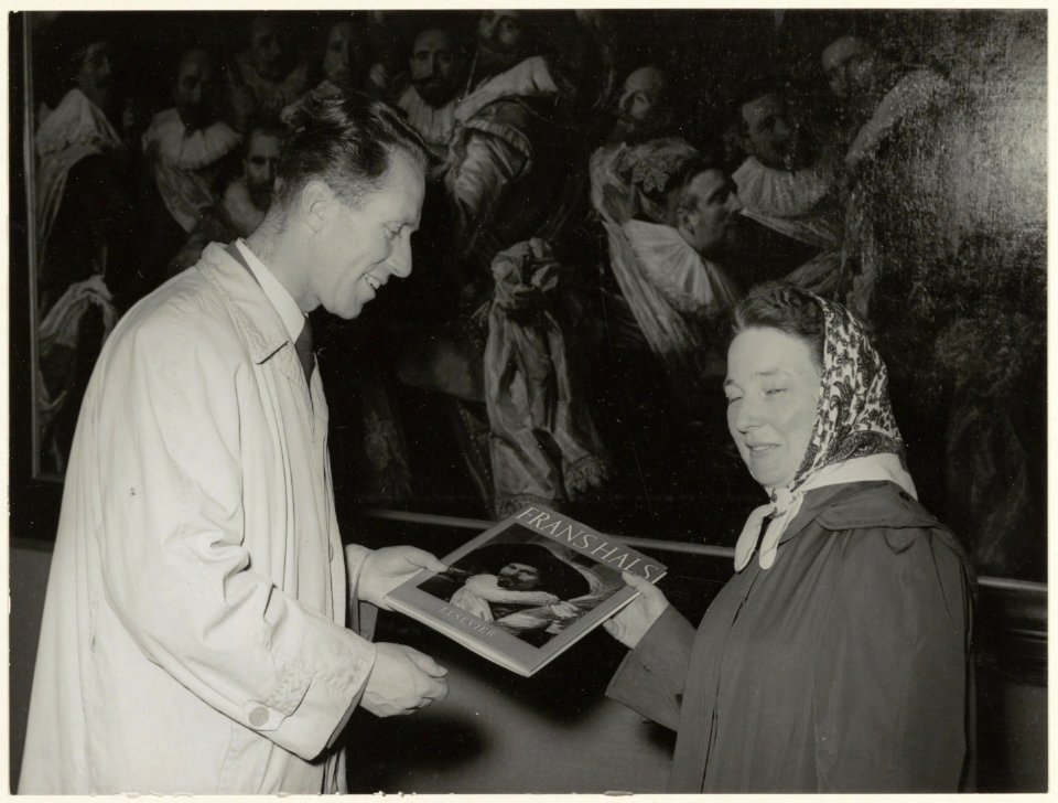Mevr. R. Borghouts is in 1953 de 20.000ste bezoeker van het Frans Halsmuseum. wethouder D.J.A. Geluk overhandigt haar een boek. NL-HlmNHA 54004257