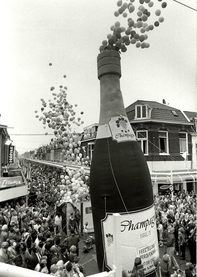 Met de 'ontkurking' van een elf meter hoge champagne-fles heropende burgemeester Schmitz (rechtsonder nog net in beeld) de vernieuwde Cronjéstraat. Aangekocht van United Photos de Boer bv. - Negatiefn