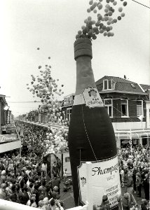 Met de 'ontkurking' van een elf meter hoge champagne-fles heropende burgemeester Schmitz (rechtsonder nog net in beeld) de vernieuwde Cronjéstraat. Aangekocht van United Photos de Boer bv. - Negatiefn