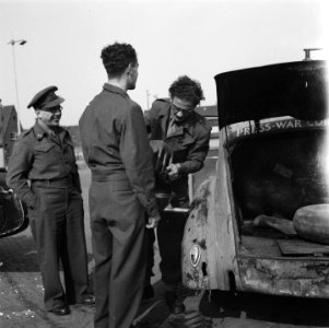 Met een jerrycan wordt de benzinetank van een auto van oorlogscorrespondenten b, Bestanddeelnr 900-5777