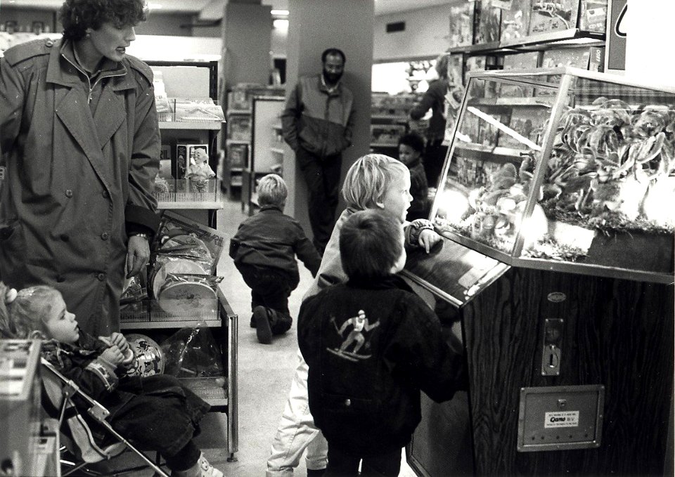 Met open mond kijken grote en kleine mensen naar de muzikale aapjes in de Bimbobox op de speelgoedafdeling van Vroom en Dreesmann aan het Verwulft. Aangekocht in 1988 van United Photos de Boer bv. - N