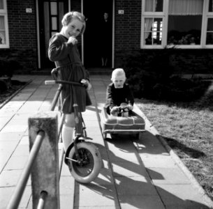 Marietje, de achtjarige dochter van Gerard, op haar autoped in de voortuin, same, Bestanddeelnr 254-3303