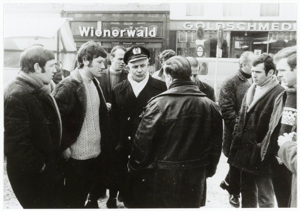 Marktkooplieden in gesprek met marktmeester Moonen. Op de rug gezien Theo v.d. Horst. NL-HlmNHA 54003384