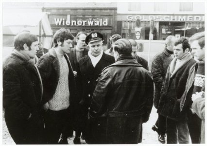 Marktkooplieden in gesprek met marktmeester Moonen. Op de rug gezien Theo v.d. Horst. NL-HlmNHA 54003384