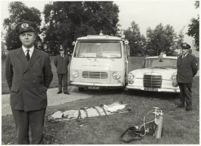 Medewerkers van de G.G. en G.D. poseren voor de nieuwe ambulancevoertuigen op het Prinsen Bolwerk. NL-HlmNHA 54012084