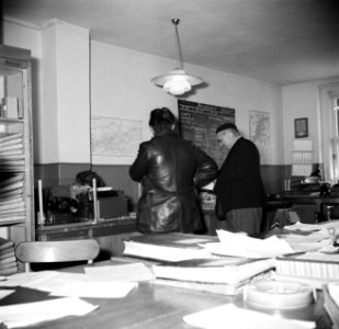Medewerkster achter loket in het kantoor van rederij Damco in Emmerich met 2 ma…, Bestanddeelnr 254-0980