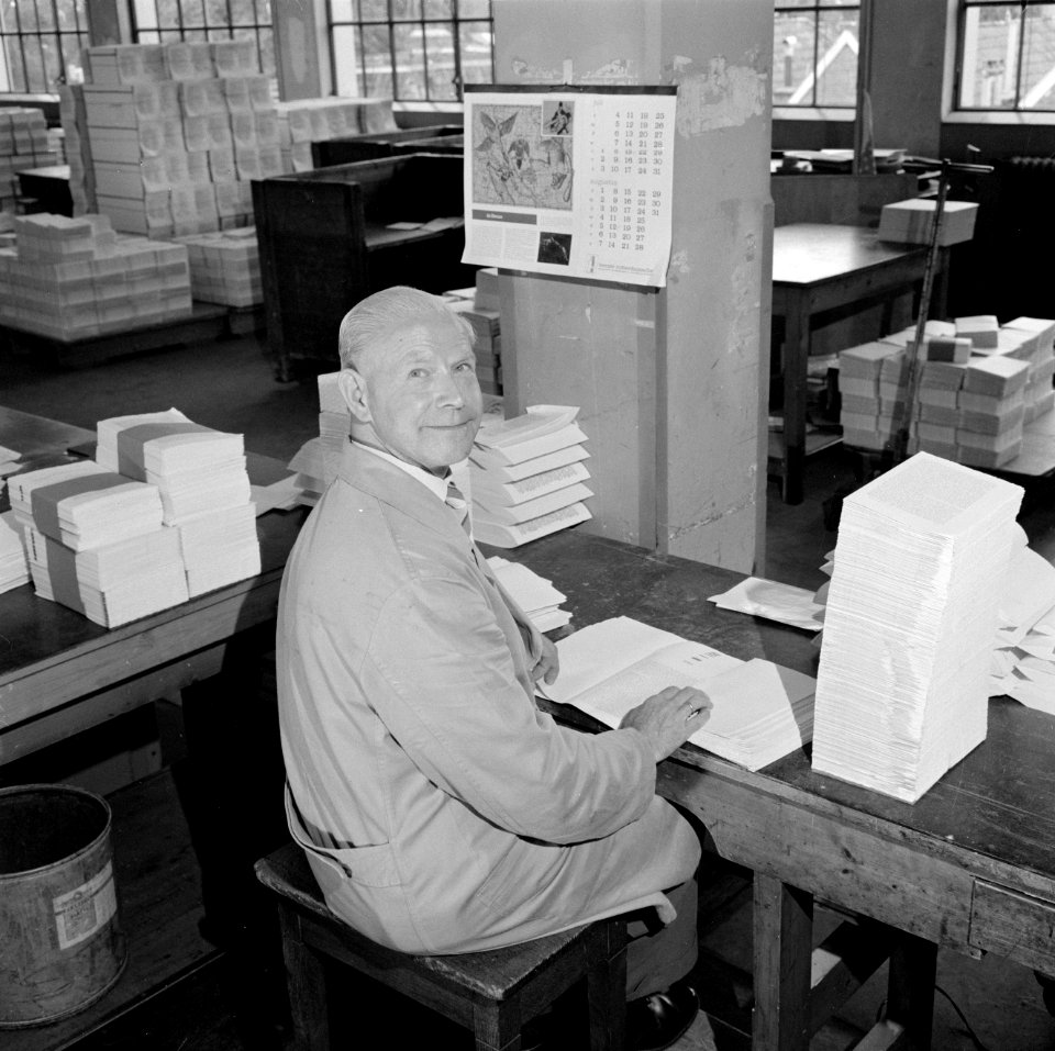 Medewerker met boeken in losse katernen, Bestanddeelnr 254-5287