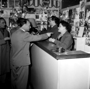 Meester Carletti en zijn moeder achter de bar van de school. Aan de muren hangen, Bestanddeelnr 254-0133