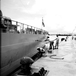 Matrozen bezig met het schoonschrobben van de HM De Ruyter in de haven van Wille, Bestanddeelnr 252-3228