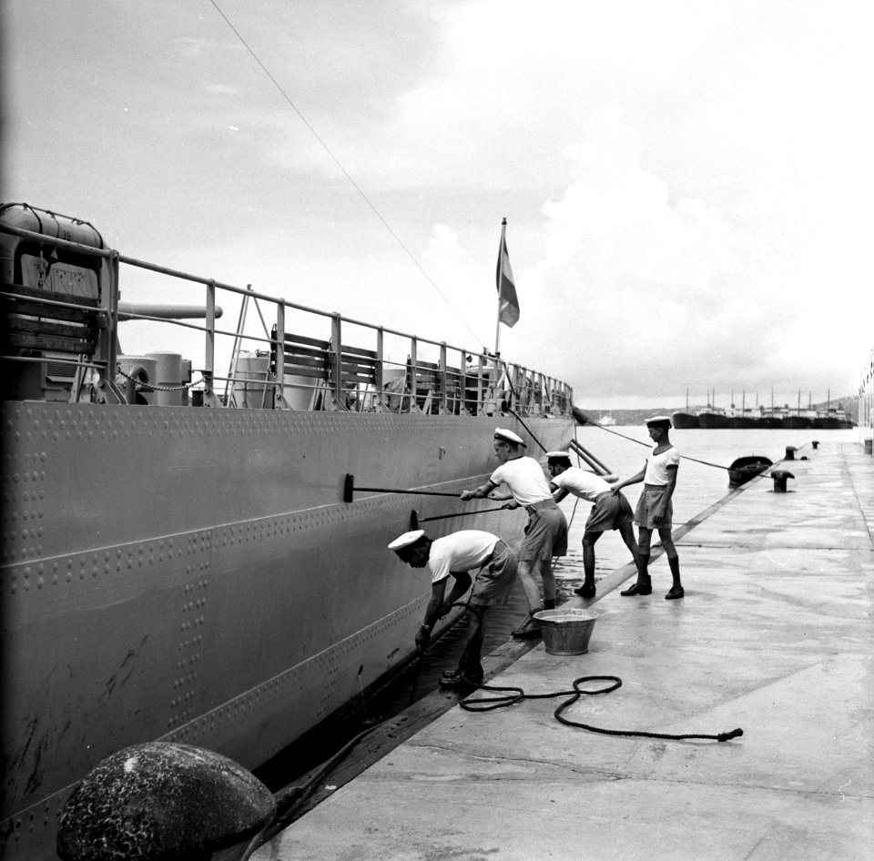 Matrozen bezig met het schoonschrobben van de HM De Ruyter in de haven van Wille, Bestanddeelnr 252-3227