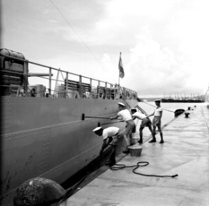 Matrozen bezig met het schoonschrobben van de HM De Ruyter in de haven van Wille, Bestanddeelnr 252-3227