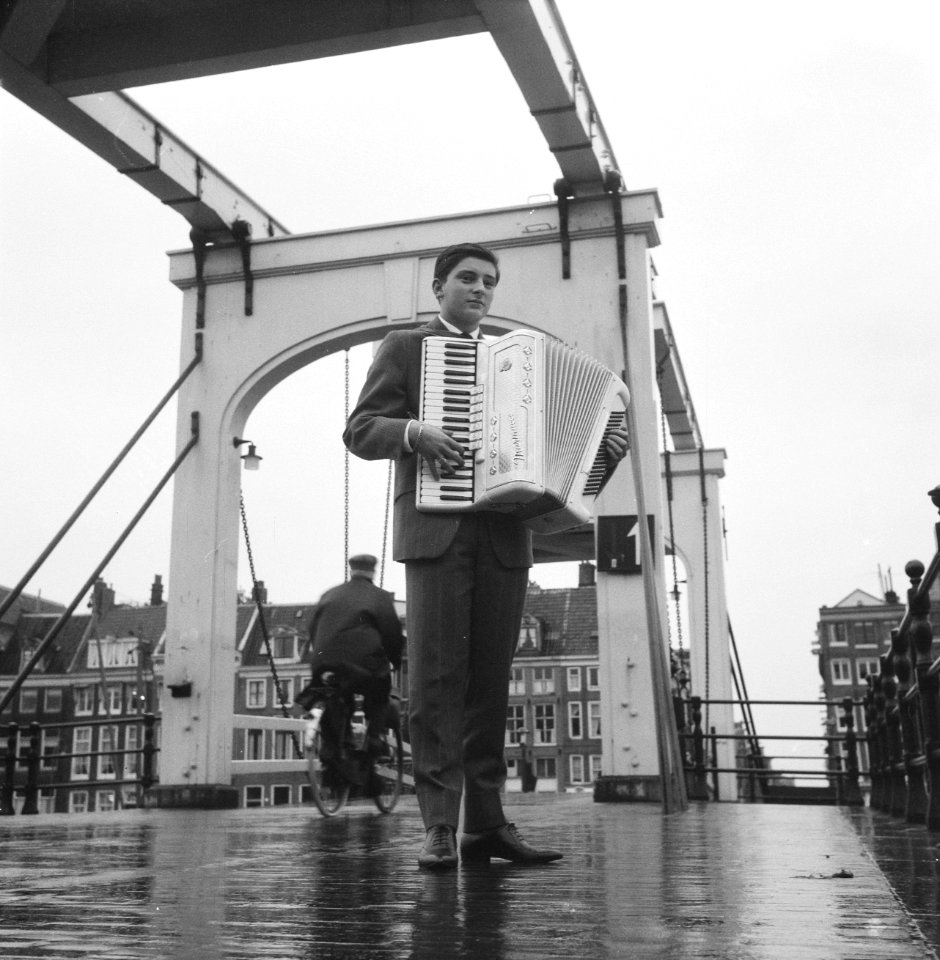 Maurice Nuisker, wereldkampioen accordeonspelen, voor de Magere Brug in Amsterda, Bestanddeelnr 913-0937