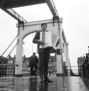 Maurice Nuisker, wereldkampioen accordeonspelen, voor de Magere Brug in Amsterda, Bestanddeelnr 913-0937