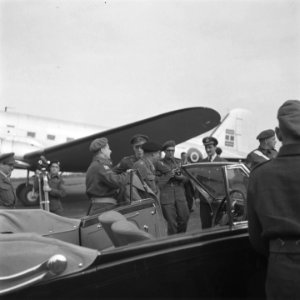 Montgomery wordt in een overjas geholpen voor het vertrek van het vliegveld in g, Bestanddeelnr 900-7456