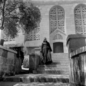 Monnik, vermoedelijk een franciscaan, in habijt op de trappen voor de kerk van d, Bestanddeelnr 255-0443 photo