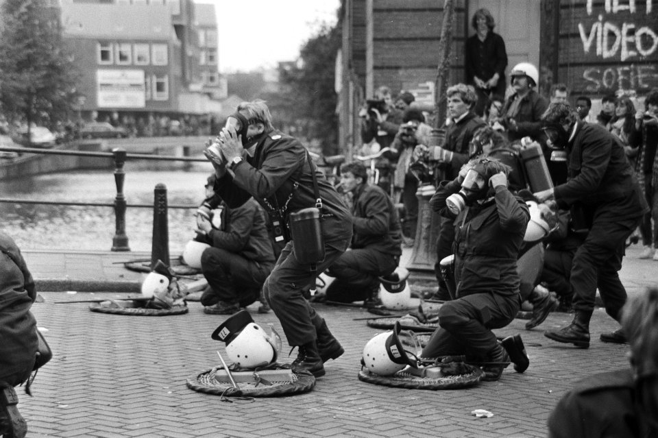 Mobiele Eenheid met gasmaskers op de achtergrond een politie-auto, Bestanddeelnr 931-7295