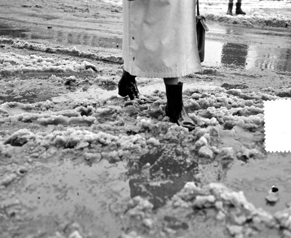 Moddergenoegens. Vrouw stapt door moddersneeuw, Bestanddeelnr 904-9558