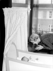 Model Eva Waldschmidt met baby Epko die in zijn wiegje ligt, Bestanddeelnr 189-1092
