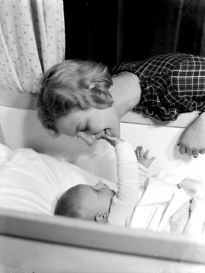 Model Eva Waldschmidt met baby Epko die in zijn wiegje ligt, Bestanddeelnr 189-1091