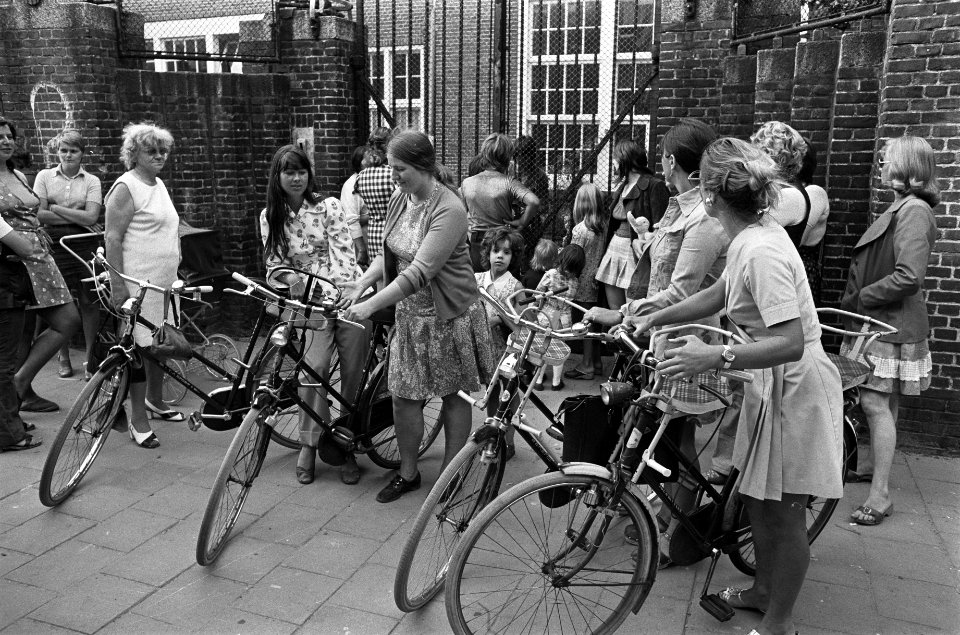 Moeders met fietsen halen kinderen af bij kleuterschool, opdracht Volkskrant, Bestanddeelnr 927-4010