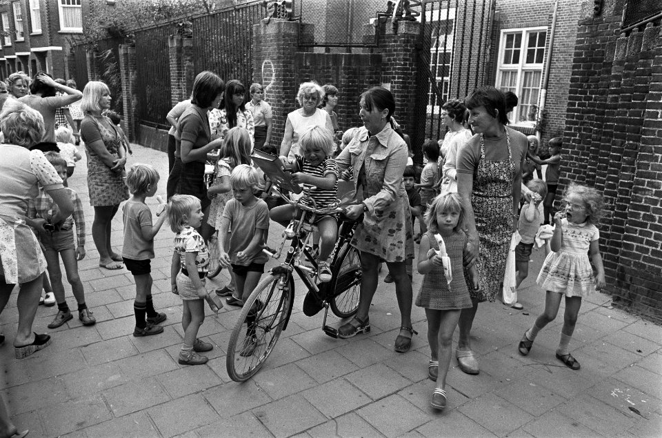 Moeders met fietsen halen kinderen af bij kleuterschool, opdracht Volkskrant, Bestanddeelnr 927-4012