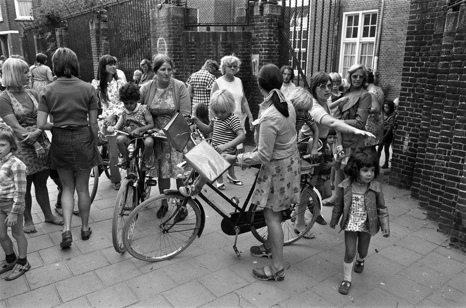 Moeders met fietsen halen kinderen af bij kleuterschool, opdracht Volkskrant, Bestanddeelnr 927-4009