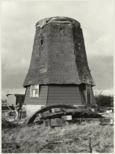Molen de Veer ( zonder kap en wieken) tijdens de restauratie met Cees Fray bezig met het schoonbikken van het metselwerk. NL-HlmNHA 54012361