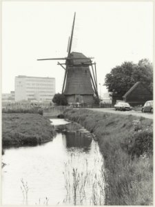 Molen de Veer in vervallen staat, met het gebouw van NRM op de achtergrond. NL-HlmNHA 54012390