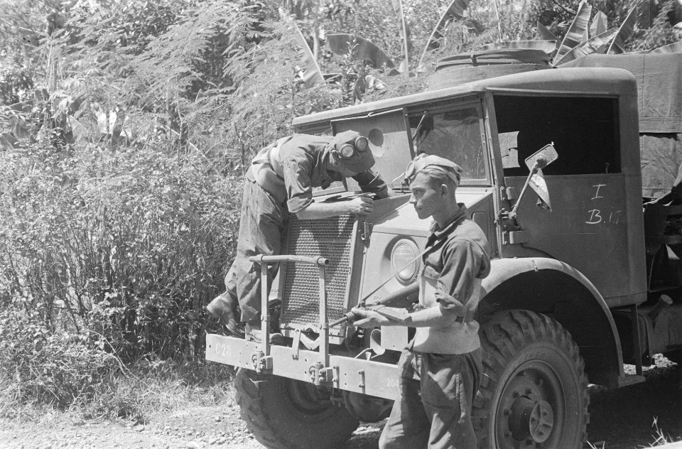 Motor van een drietonner wordt nagekeken terwijl een andere militair de wacht h, Bestanddeelnr 38-3-3
