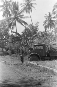 Motor van een drietonner wordt nagekeken terwijl een andere militair de wacht h, Bestanddeelnr 38-3-4