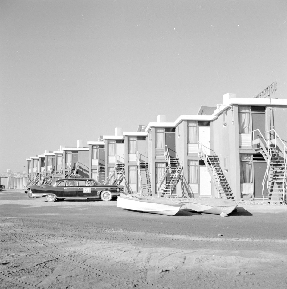 Motel Tropicana in Eilat met daarvoor twee roeibootjes en een personenauto, Bestanddeelnr 255-3601