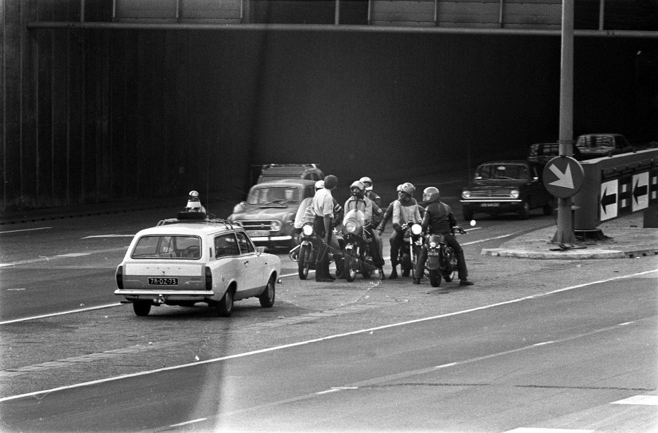 Motorrijders staan stil bij de uitgang van de tunnel voor een auto met zwaailic…, Bestanddeelnr 928-0422