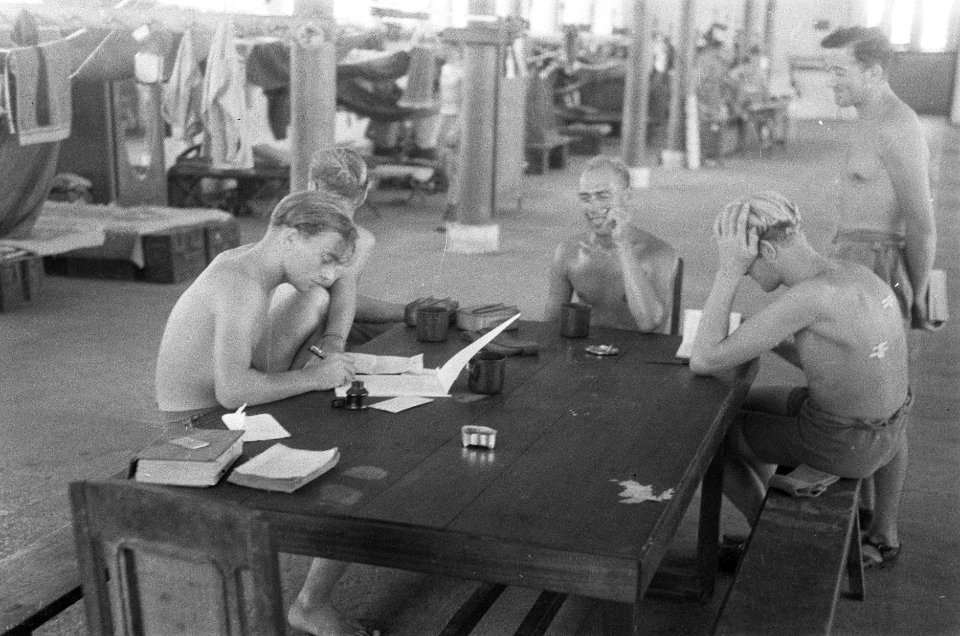 Militairen om een tafel, een van hen schrijft een brief, Bestanddeelnr 45-5-2